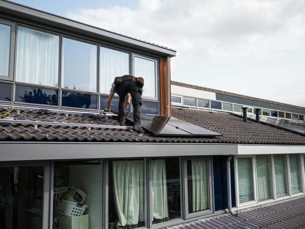 solar panels being installed on a UK residential roof, installer on scaffold